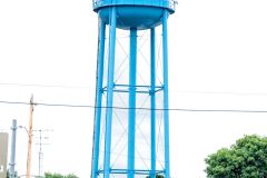Markle water tower painted light blue with a large smiley face on it.