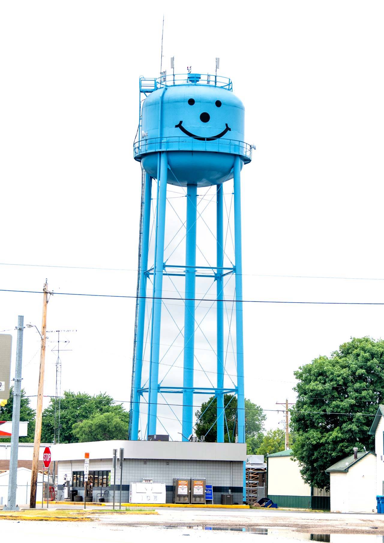 Markle water tower painted light blue with a large smiley face on it.