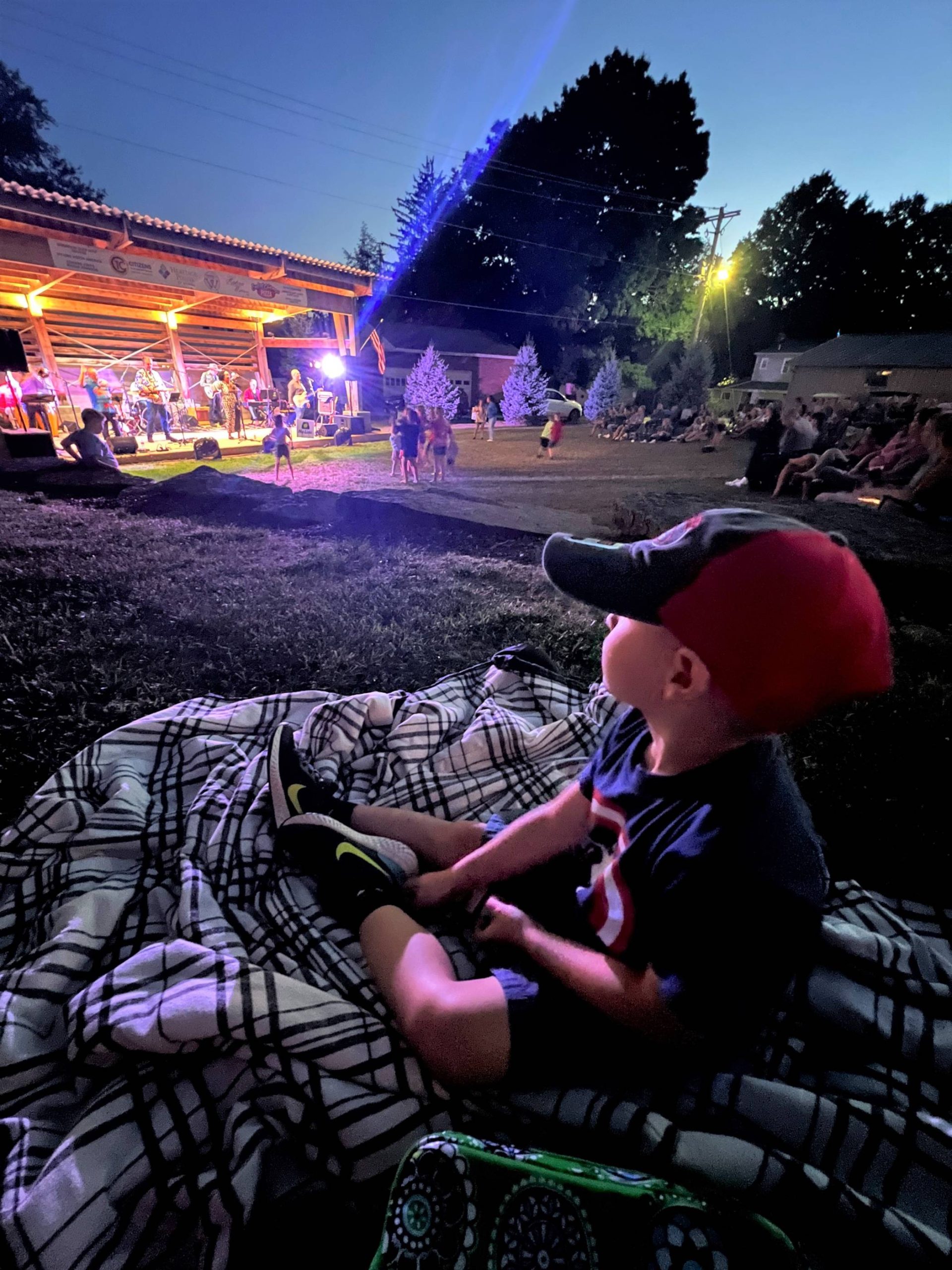 Boy sitting at an outdoor concert in Warren.